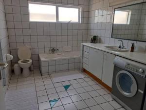 a bathroom with a toilet sink and a washing machine at House of Light in Swakopmund