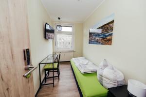 a small room with a green couch and a window at Clubhostel Dessau in Dessau