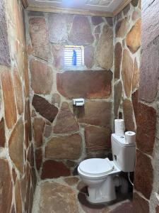 a stone bathroom with a toilet in a stone wall at Luluka Guest House in Sekenani