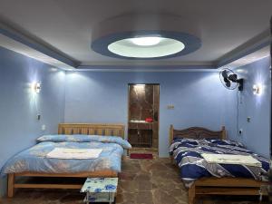 a bedroom with two beds and a large ceiling at Luluka Guest House in Sekenani