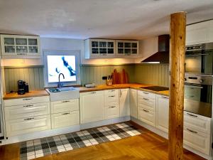 a kitchen with white cabinets and a tv in it at CHALET OSERIAN in Bad Gastein in Bad Gastein