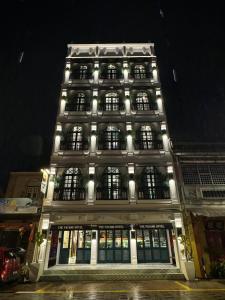 duży budynek z oświetlonymi oknami w nocy w obiekcie The Payang Hotel w mieście Kuala Terengganu
