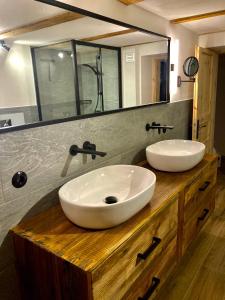 CHALET OSERIAN in Bad Gastein في باد جاستاين: حمام مع مغسلتين على منضدة خشبية مع مرآة