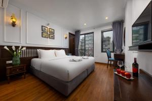 a hotel room with a large bed and a desk at Paddy Hotel in Ha Long