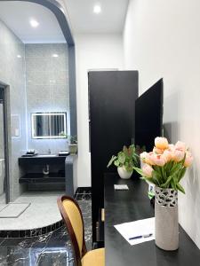 a bathroom with a table with a vase of flowers at Tây Homestay 968 in Ấp Thanh Sơn (1)