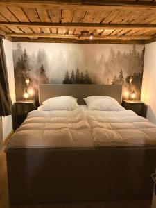 CHALET OSERIAN in Bad Gastein في باد جاستاين: غرفة نوم بسرير كبير عليها لوحة على الحائط