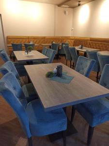 a dining room with tables and blue chairs at Hotel zur Panke Wohnung 1 in Kolonie Röntgental