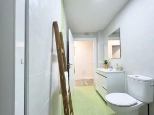 Baño blanco con aseo y lavamanos en Apartamentos Gredos 002, en Jaraíz de la Vera