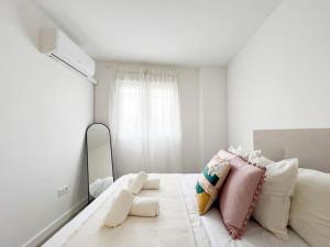 a bedroom with a bed with pillows and a mirror at Apartamentos Gredos 002 in Jaraiz de la Vera