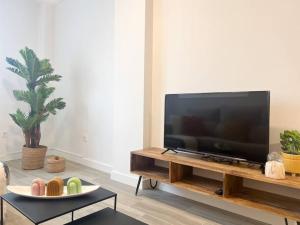a living room with a flat screen tv and a table at Apartamentos Gredos 002 in Jaraiz de la Vera
