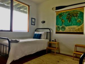 Sandy Toes في Greens Beach: غرفة نوم بسرير وخريطة على الحائط