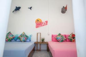 duas camas num quarto com rosa e azul em Tamtawan Guesthouse - ตามตะวันเกสเฮ้าส์ em Ko Lipe