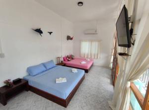 a small room with a bed and a television at Tamtawan Guesthouse Lipe - ตามตะวันเกสเฮ้าส์ หลีเป๊ะ in Ko Lipe