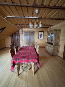 a dining room with a plaid table and chairs at Guest House Zator in Vyshkiv