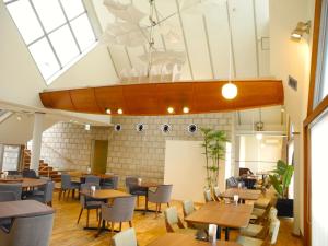 un ristorante con tavoli, sedie e lucernario di Hotel Global View Tsuchiura a Tsuchiura