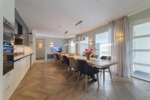 uma cozinha e sala de jantar com mesa e cadeiras em Villa Oranjezon by Droomvilla em Colijnsplaat