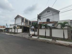 budynek z palmami przed ulicą w obiekcie D'Exclusive Guest House w mieście Tasikmalaya