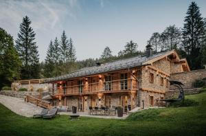 una grande casa di tronchi con portico e terrazza di Die Suttenhütte a Rottach-Egern