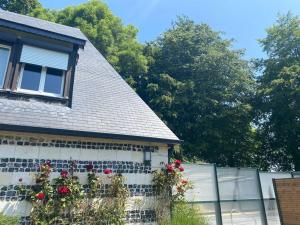 a house with flowers on the side of it at Maison 10p avec piscine, chauffée et partagée avec 1 autre gîte, horaires privatifs pour chaque gîte - Réservation sur https auxportesdetretat fr in Villainville +44 photos