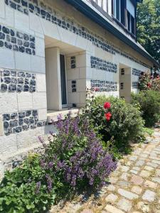 a building with some flowers in front of it at Maison 10p avec piscine, chauffée et partagée avec 1 autre gîte, horaires privatifs pour chaque gîte - Réservation sur https auxportesdetretat fr in Villainville