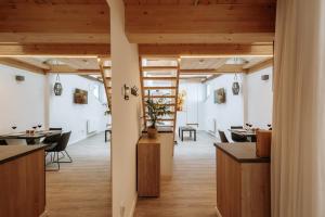 a room with tables and chairs and wooden ceilings at Modern Elegance Lofts - Wohnen auf zwei Ebenen in Passau