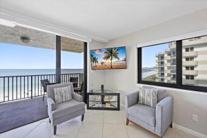 a living room with two chairs and a view of the ocean at Seawinds 706 in Marco Island