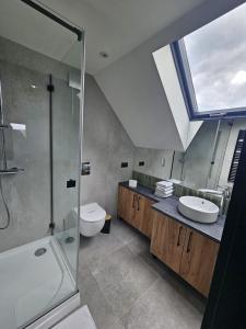 ein Bad mit einem Waschbecken, einem WC und einem Fenster in der Unterkunft Domek LUNA in Olchowiec