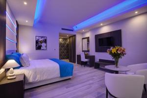 a hotel room with a bed and a tv at The Josephine Boutique Hotel in Larnaka