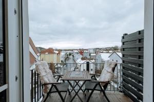 balcón con mesa de madera y 2 sillas en Modern Elegance Lofts - Wohnen auf zwei Ebenen, en Passau