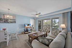 a living room with a couch and a table at Coastal style condo with pool, spa and steps to beach in Marco Island