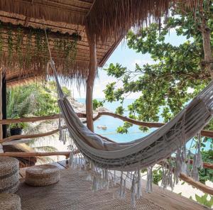 a hammock in a straw hut with a view of the ocean at Why Nam Beach in Haad Yuan