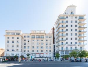 un gran edificio blanco en una calle de la ciudad en Phoenix Luxury Loft Cádiz, en Cádiz