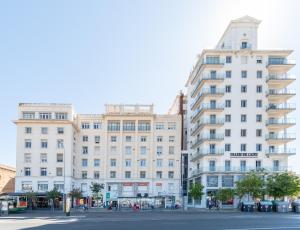duży biały budynek przy ulicy miejskiej w obiekcie Phoenix Luxury Loft Cádiz w Kadyksie