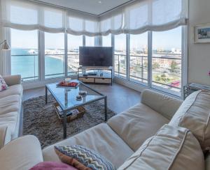 sala de estar con sofá y TV en Phoenix Luxury Loft Cádiz, en Cádiz