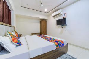 FabExpress Radhe Residency في أحمد آباد: غرفة نوم بسرير وحطوق لكرة السلة
