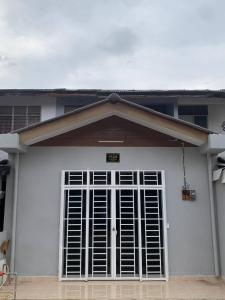 uma porta de garagem branca com um sinal em Zahra Homestay em Rantau Panjang