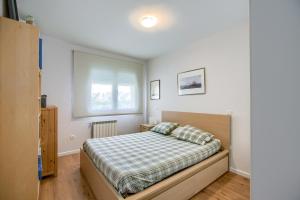 ein Schlafzimmer mit einem Bett mit einer karierten Decke in der Unterkunft Chalet con Piscina en Aranjuez in Aranjuez