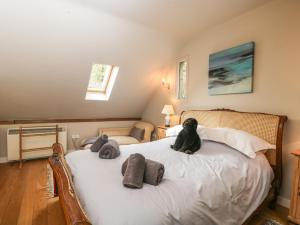 a teddy bear sitting on top of a bed at The Barn at Westhall Cottage in Burford