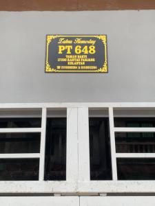 a sign on the side of a building with windows at Zahra Homestay in Rantau Panjang