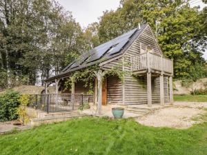 a small wooden house with a porch and a balcony at The Barn at Westhall Cottage in Burford