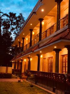 a large building with a balcony on top of it at Surendram Villa in Varkala