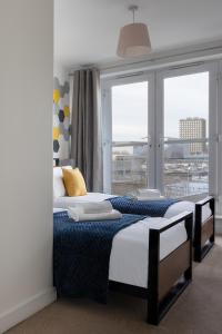 - une chambre avec 2 lits et une grande fenêtre dans l'établissement Jade Apartments Basildon, à Basildon