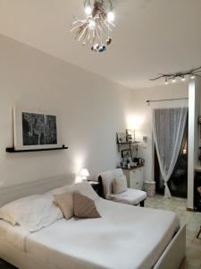 a white bedroom with a bed and a chandelier at B&B Villa Nonna Maria in Castellana Grotte +88 photos