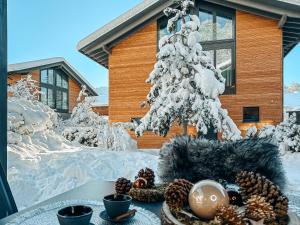 a table with a christmas tree in front of a house at ZSAM Chalets mit Sauna und Hottub in Garmisch-Partenkirchen