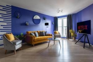 a living room with a yellow couch and blue walls at Jade Apartments Basildon in Basildon
