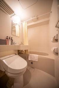 a white bathroom with a toilet and a sink at JA Hotel Bentencho 弁天町 in Osaka