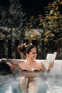 a woman in a bath tub reading a book at Troadkasten - Nationalpark Kalkalpen in Ramsau