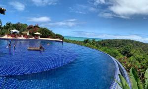 a large swimming pool with a view of the ocean at apartamento superior quarto&sala in Maceió