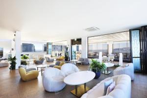 een lobby met witte stoelen, tafels en ramen bij Hotel The Sea Star in Incheon