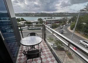 a balcony with a table and a view of a street at Crown Royale Hotel & Lounge in Port Vila